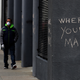 Pedestrians walk by graffiti encouraging the wearing of masks on April 20, 2020 in San Francisco, California.